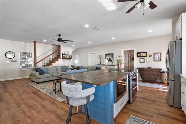 a kitchen with stainless steel appliances granite countertop a sink a stove and a wooden floors