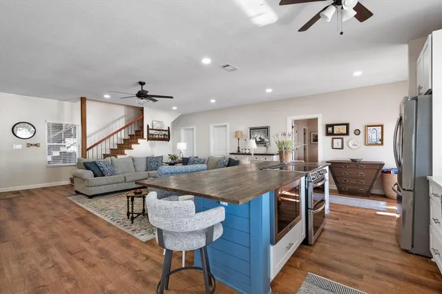 a kitchen with stainless steel appliances granite countertop a sink a stove and a wooden floors