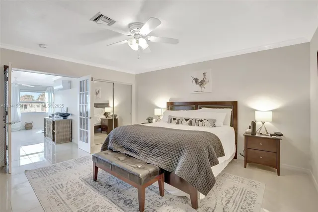 a bedroom with a bed lamps and chairs