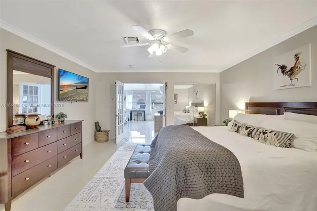 a spacious bedroom with a large bed and a chandelier