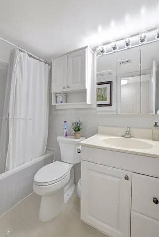 a bathroom with a toilet sink a mirror and vanity