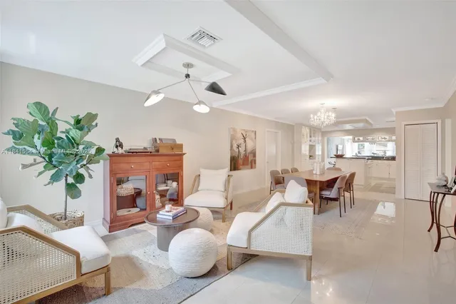 a living room with furniture a chandelier and a dining room