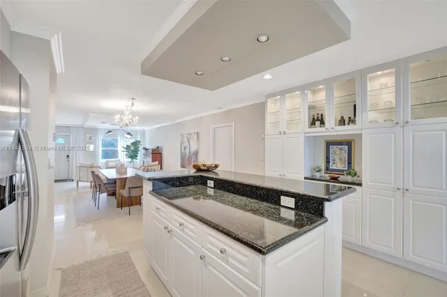 a kitchen that has a sink a stove and chairs