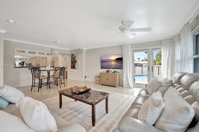 a living room with furniture a flat screen tv and a large window