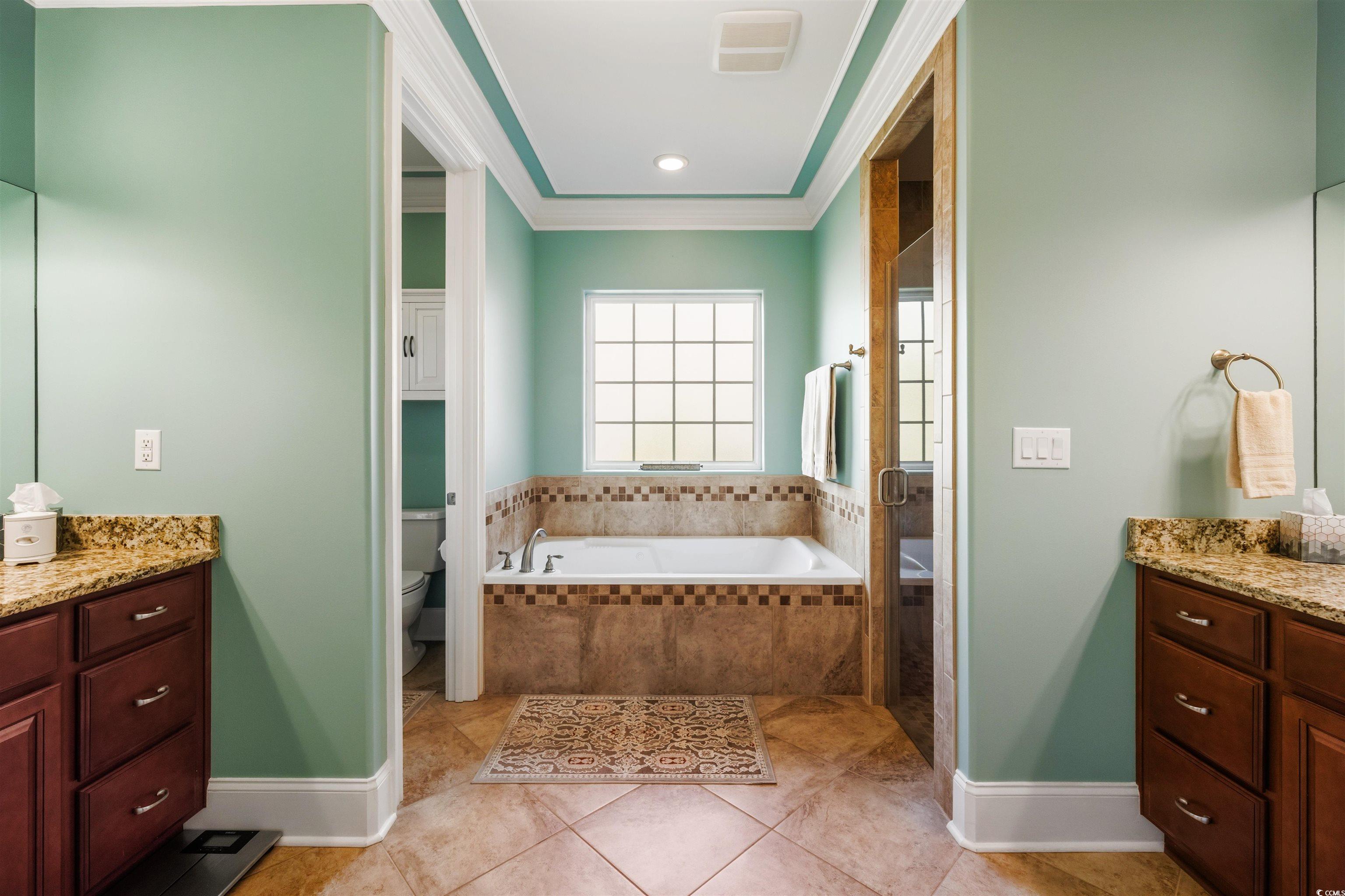 2073 Timmerman Road Myrtle Beach, SC 29588 - Photo 13 of 34 Bathroom with dual vanities, a garden tub, ornamental molding, a shower stall, and light tile patterned floors