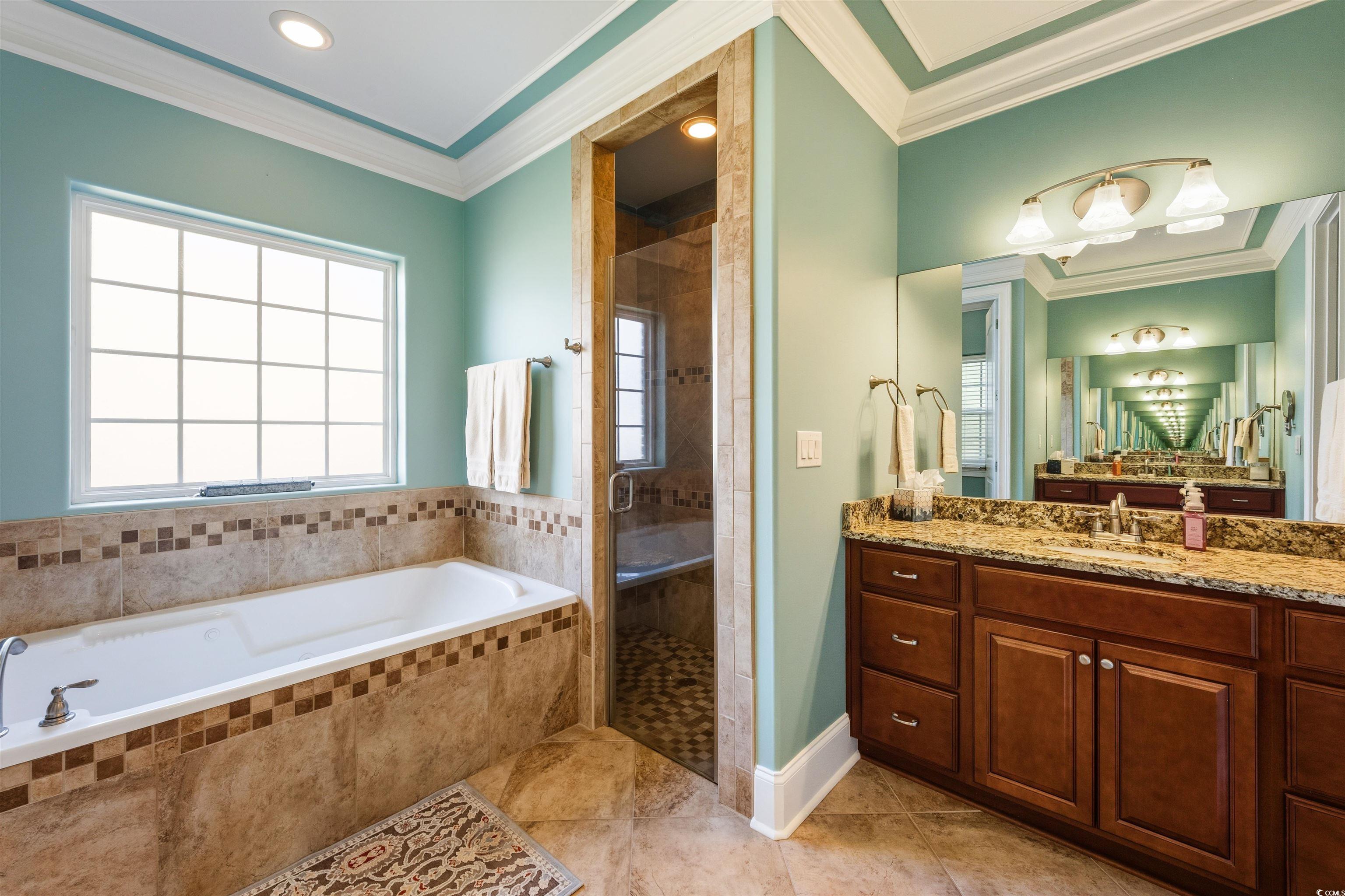 2073 Timmerman Road Myrtle Beach, SC 29588 - Photo 14 of 34 Full bath with crown molding, a garden tub, dual vanities, a stall shower, and light tile patterned floors