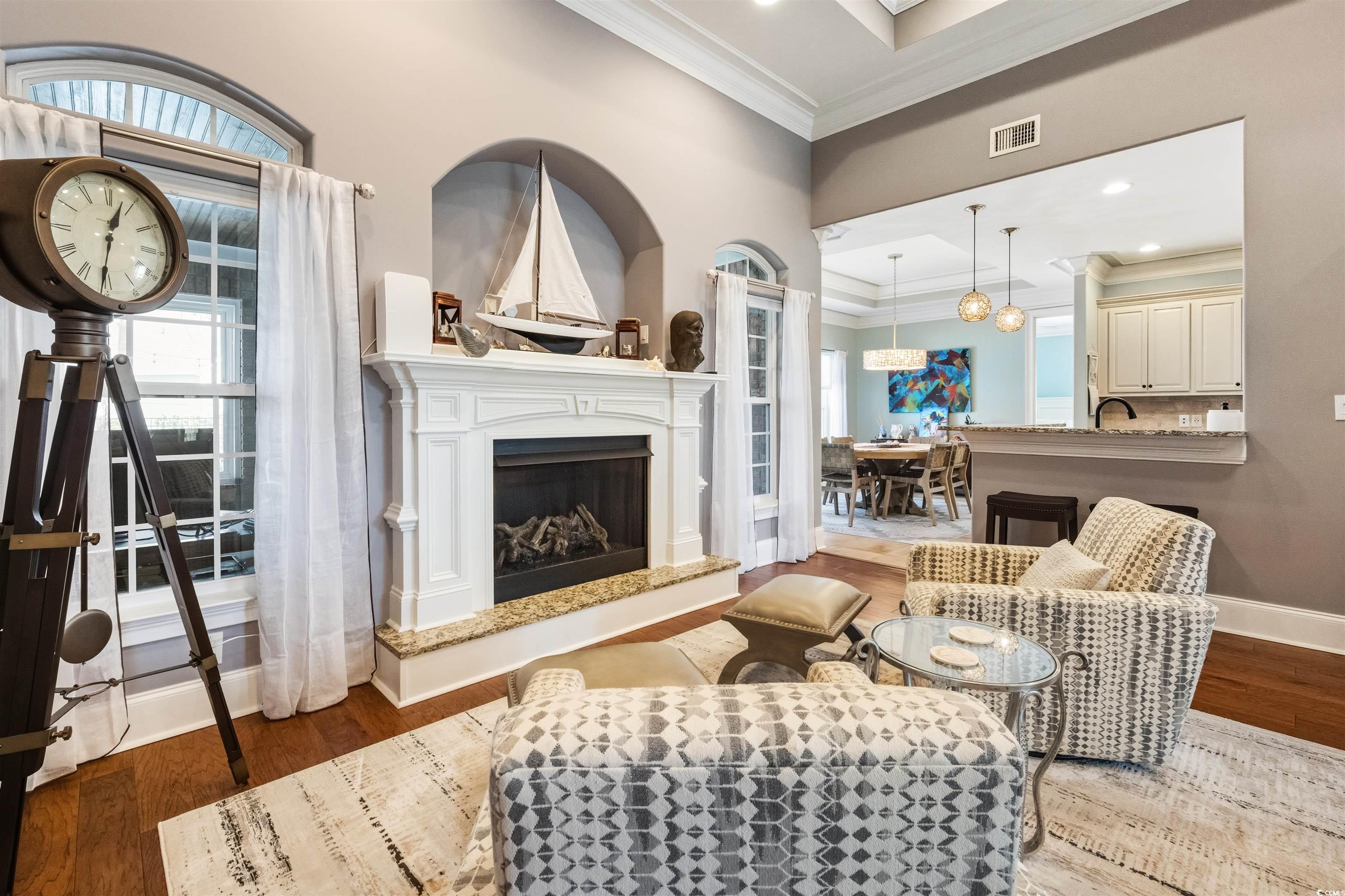 2073 Timmerman Road Myrtle Beach, SC 29588 - Photo 3 of 34 Living area with wood finished floors, crown molding, a high end fireplace, and healthy amount of natural light