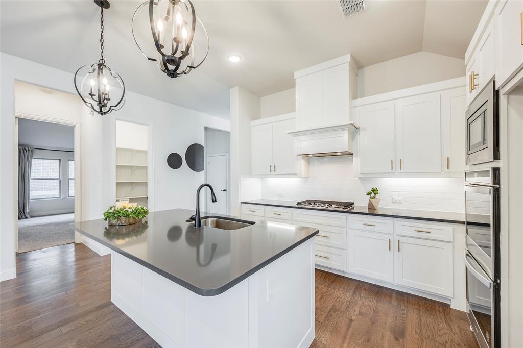 14304 Spitfire Trail Fort Worth, TX 76262 - Photo 12 of 31 a kitchen with kitchen island granite countertop a sink a stove and cabinets