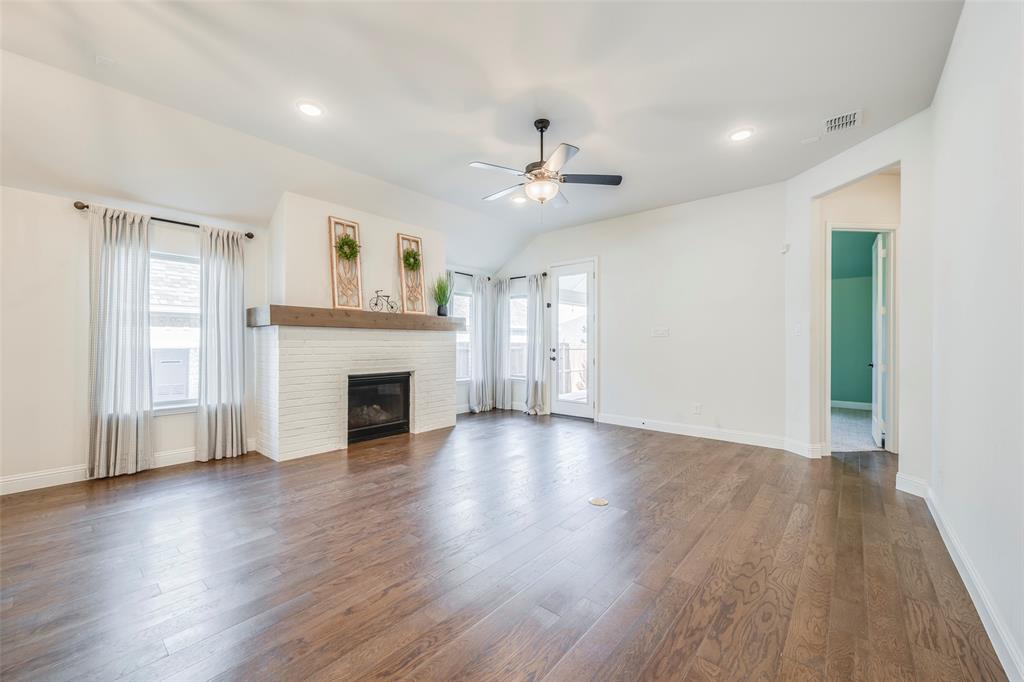 14304 Spitfire Trail Fort Worth, TX 76262 - Photo 14 of 31 an empty room with wooden floor fireplace and windows
