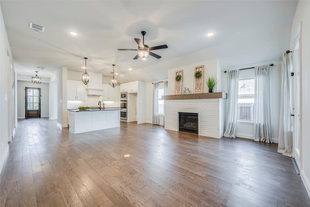 14304 Spitfire Trail Fort Worth, TX 76262 - Photo 2 of 31 a view of an empty room and kitchen with fireplace wooden floor