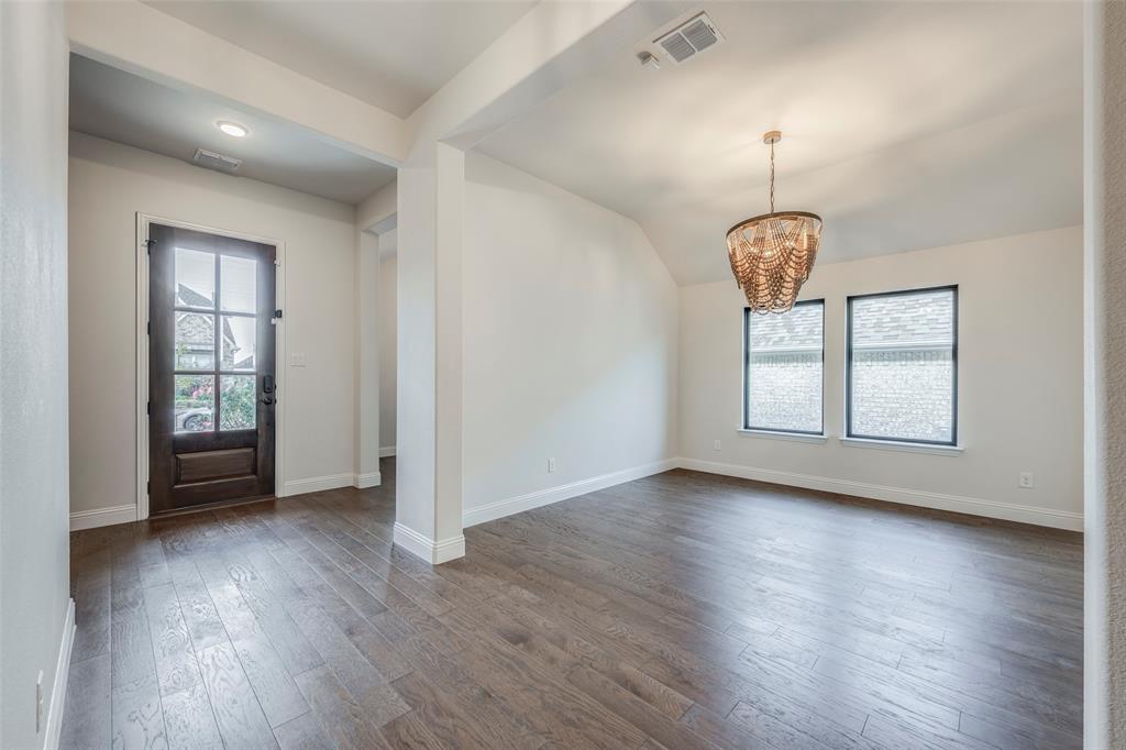 14304 Spitfire Trail Fort Worth, TX 76262 - Photo 4 of 31 an empty room with wooden floor chandelier and windows