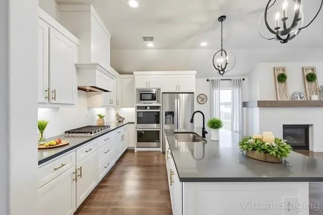a kitchen with kitchen island stainless steel appliances a sink stove and cabinets