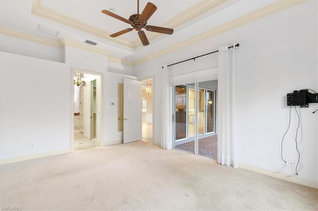 a view of a livingroom with a ceiling fan & windows