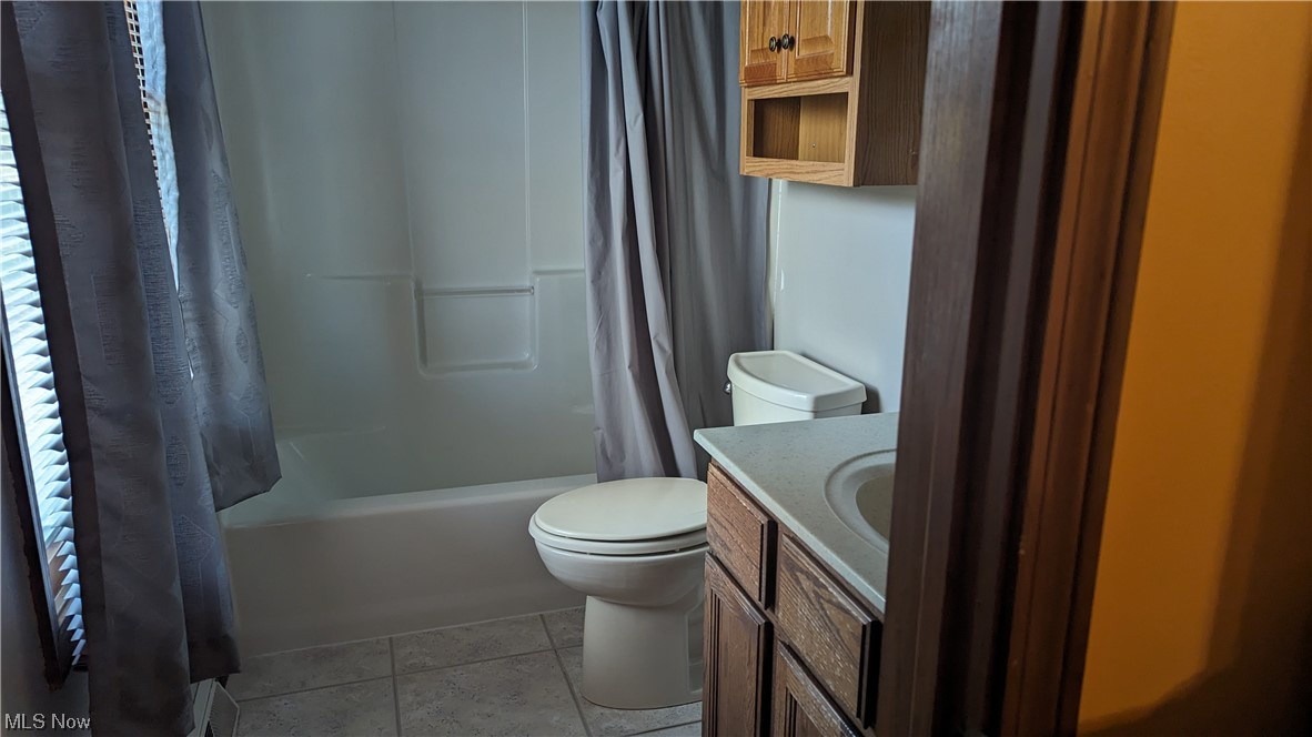 1531 Bravado Road Southwest Canton, OH 44706 - Photo 19 of 31 Full bathroom featuring shower / bath combination with curtain, toilet, vanity, and tile floors
