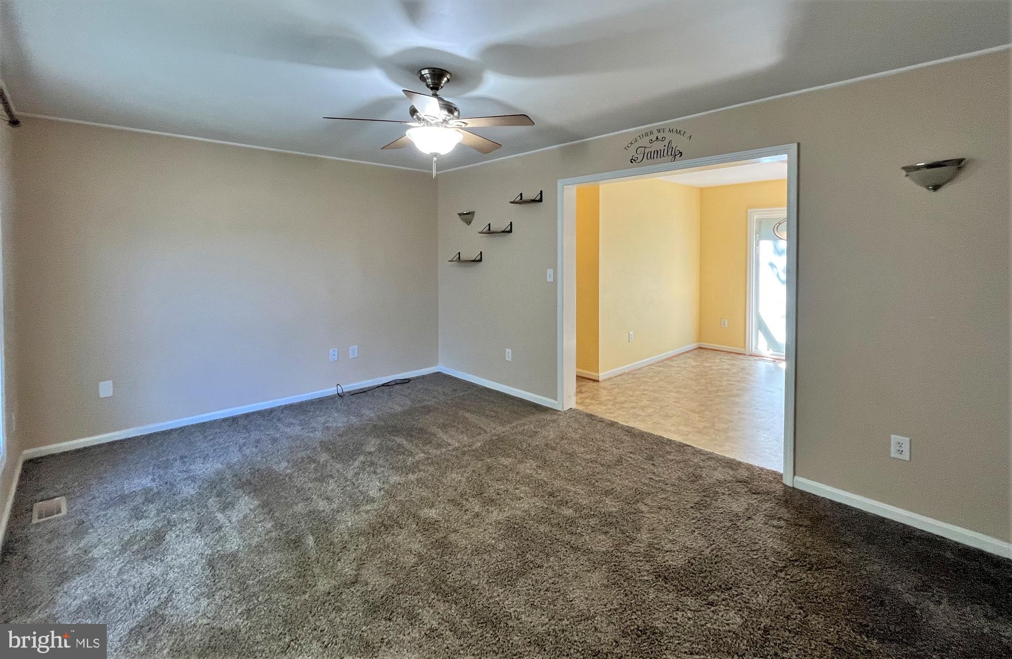 157 Cove Point Road Lusby, MD 20657 - Photo 2 of 19 an empty room with a chandelier fan and windows
