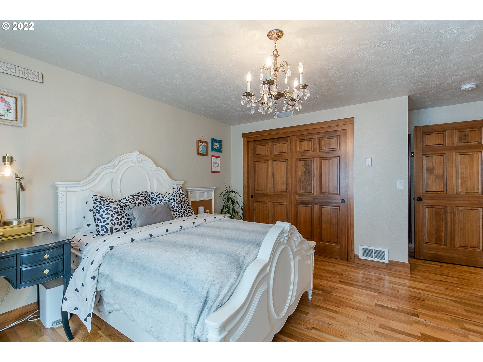 2115 Bedford Way Eugene, OR 97401 - Photo 21 of 32 a bedroom with a large bed and a chandelier