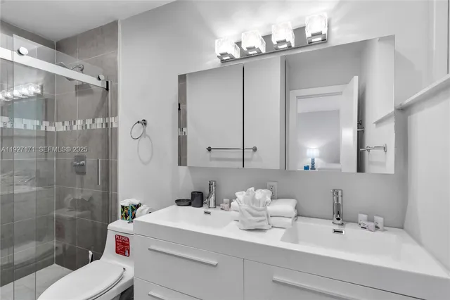 a bathroom with a sink vanity mirror and toilet