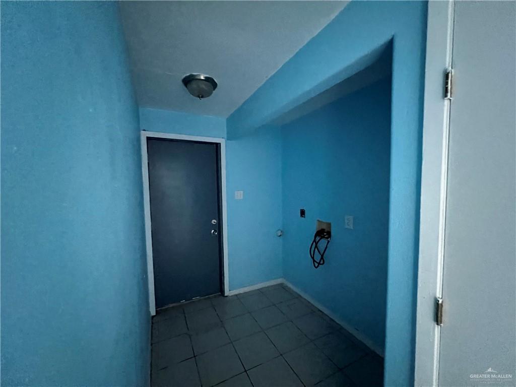 1015 Martinez Street Weslaco, TX 78596 - Photo 8 of 10 Laundry area with hookup for an electric dryer, dark tile patterned floors, washer hookup, and gas dryer hookup