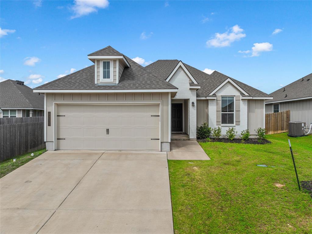 a front view of a house with yard and green space