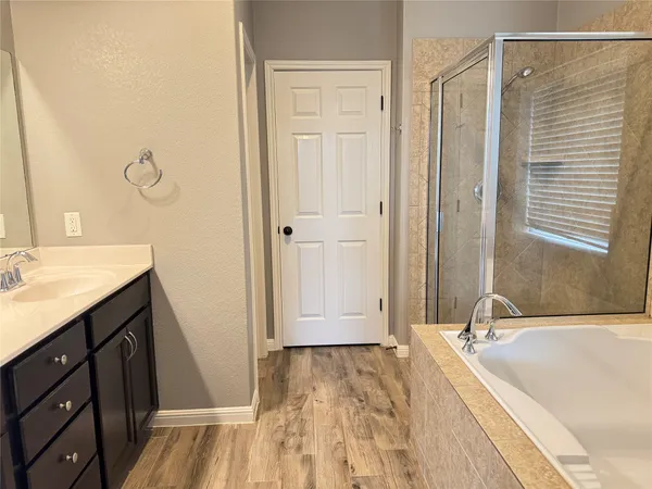 a spacious bathroom with a tub shower and sink