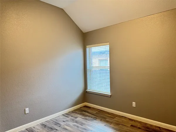 a view of a room with wooden floor and a window