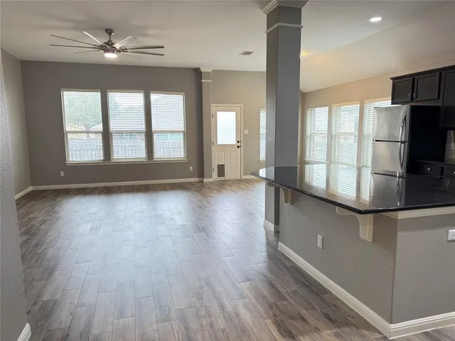 an empty room with wooden floor and outdoor space