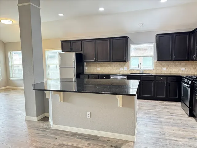 a kitchen with stainless steel appliances granite countertop a sink counter space and cabinets
