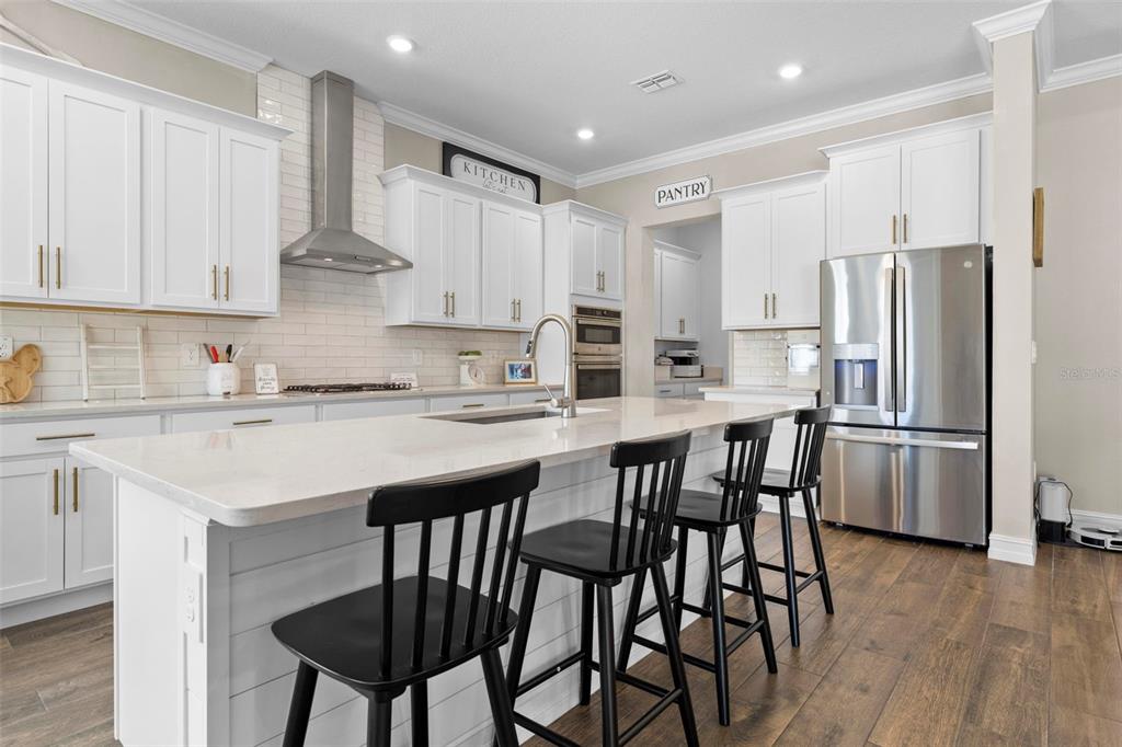 4898 Southern Valley Loop Brooksville, FL 34601 - Photo 29 of 81 a kitchen with stainless steel appliances white cabinets and wooden floor