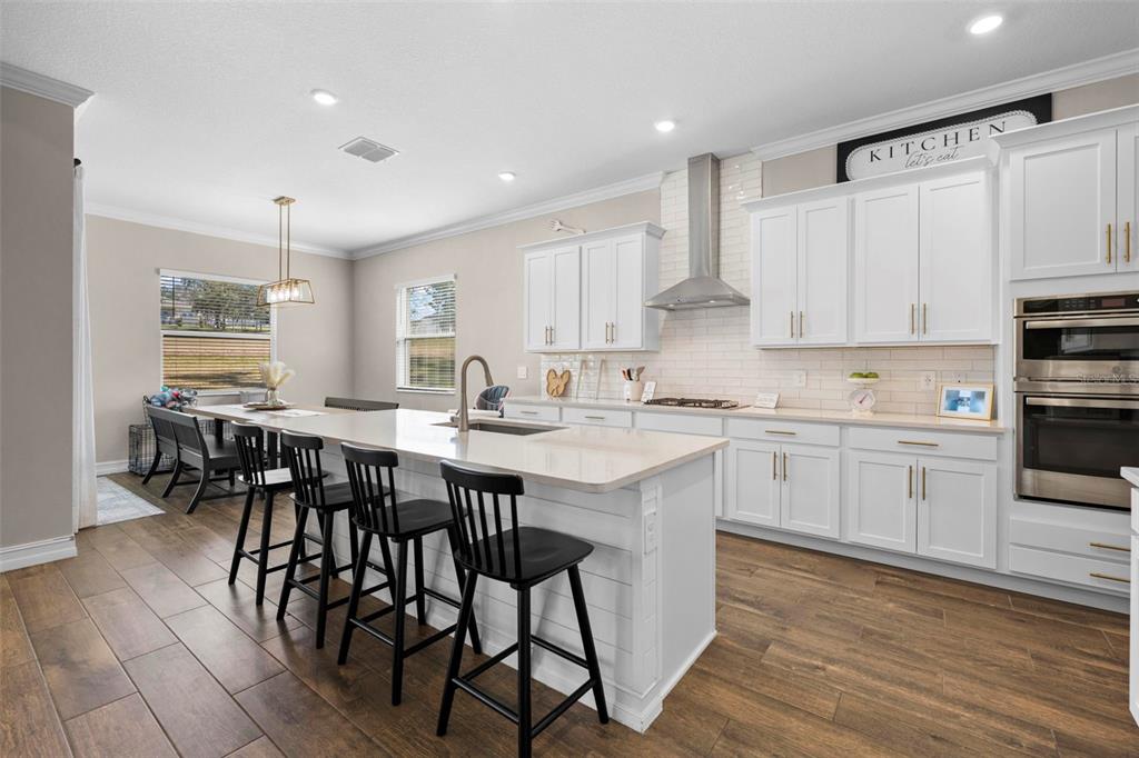 4898 Southern Valley Loop Brooksville, FL 34601 - Photo 31 of 81 a kitchen with stainless steel appliances kitchen island granite countertop a table chairs sink and cabinets