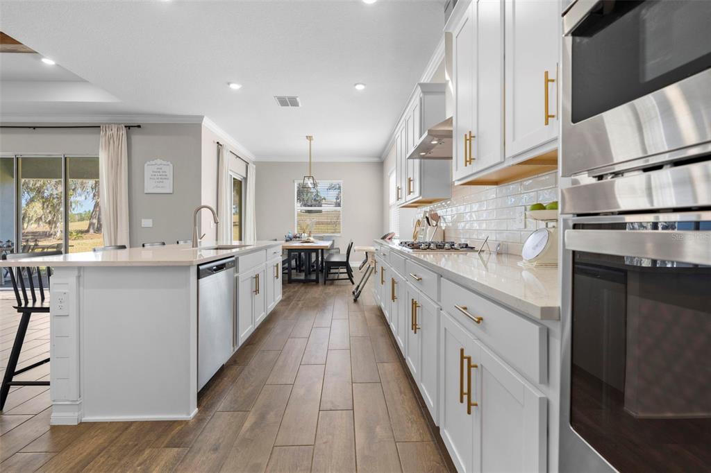4898 Southern Valley Loop Brooksville, FL 34601 - Photo 33 of 81 a large kitchen with stainless steel appliances kitchen island granite countertop a stove a sink and a refrigerator