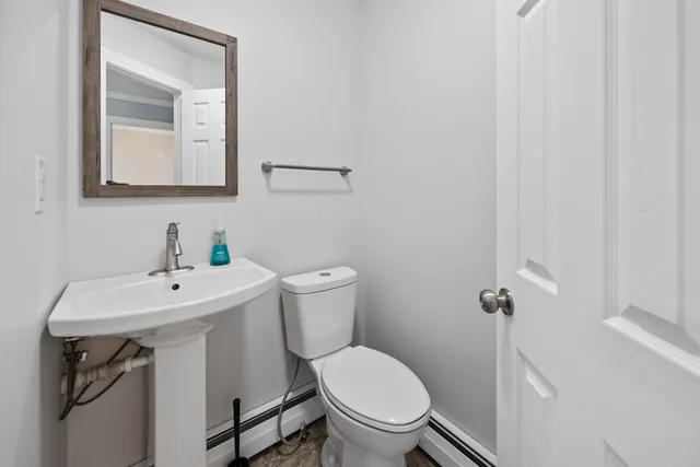a bathroom with a toilet sink and mirror