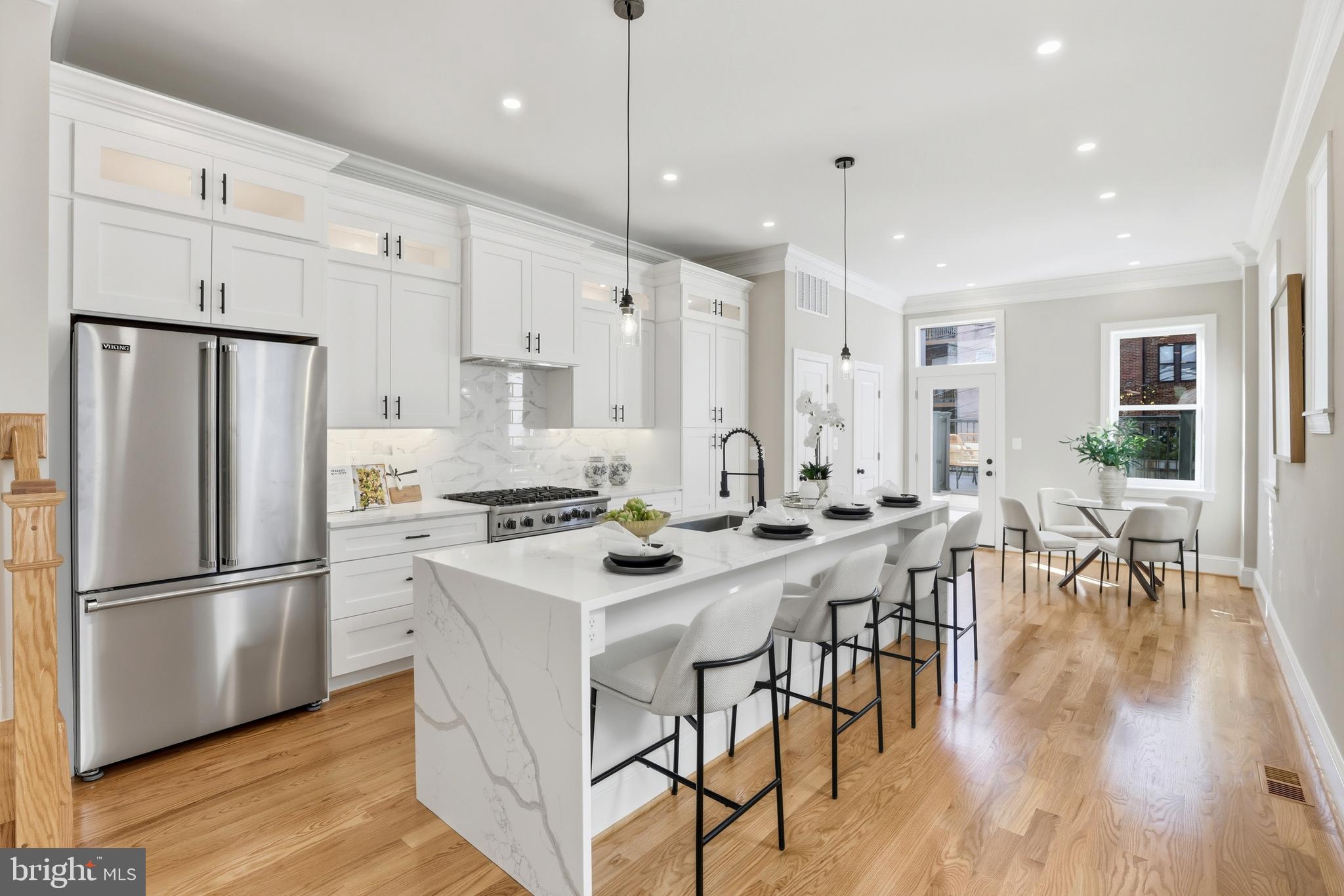 910 Westminster Street Northwest Washington, DC 20001 - Photo 12 of 66 a kitchen with stainless steel appliances a dining table chairs stove refrigerator and cabinets