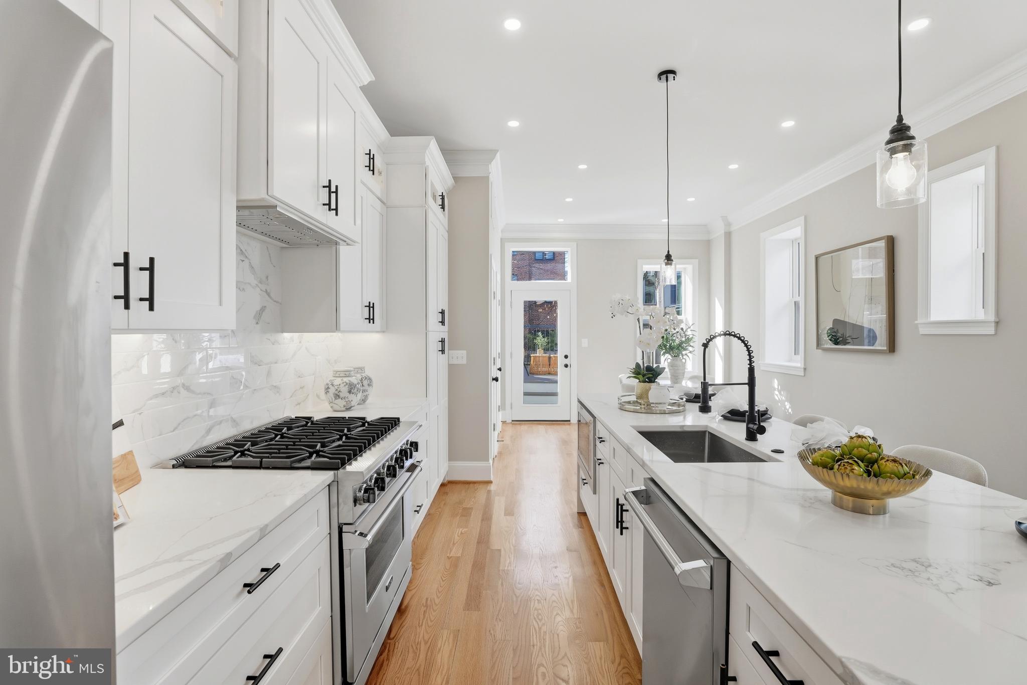 910 Westminster Street Northwest Washington, DC 20001 - Photo 16 of 66 a kitchen with a sink stove and white cabinets