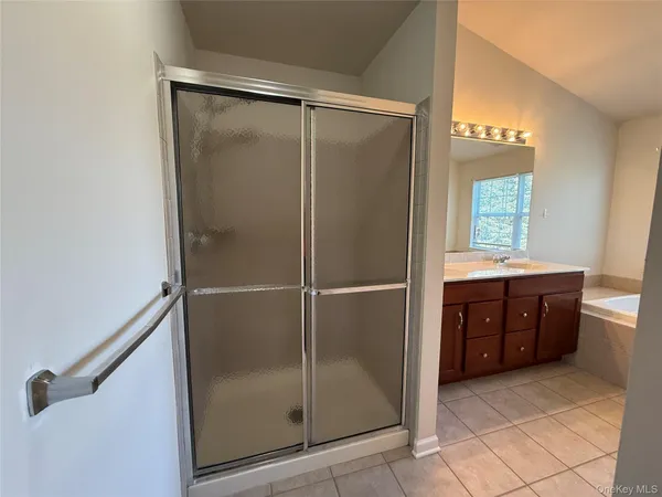 a bathroom with a tub a sink and mirror