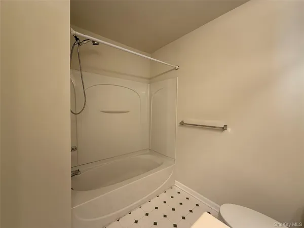 a bathroom with a granite countertop toilet and a shower