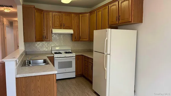 a kitchen with a refrigerator sink and cabinets