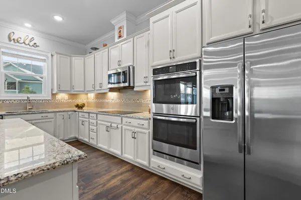 a kitchen with stainless steel appliances granite countertop a sink and a stove