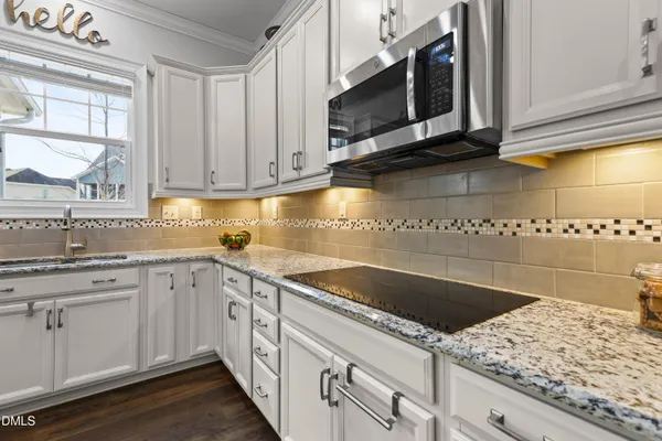 a kitchen with stainless steel appliances granite countertop room island wooden floor and refrigerator