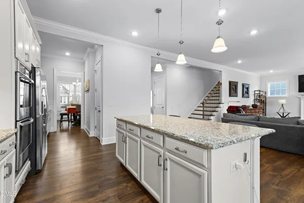 a kitchen with granite countertop a sink cabinets and wooden floor