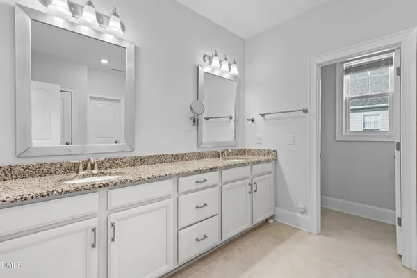 a bathroom with a granite countertop toilet sink and mirror