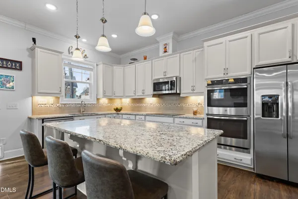 a kitchen with granite countertop stainless steel appliances and white cabinets