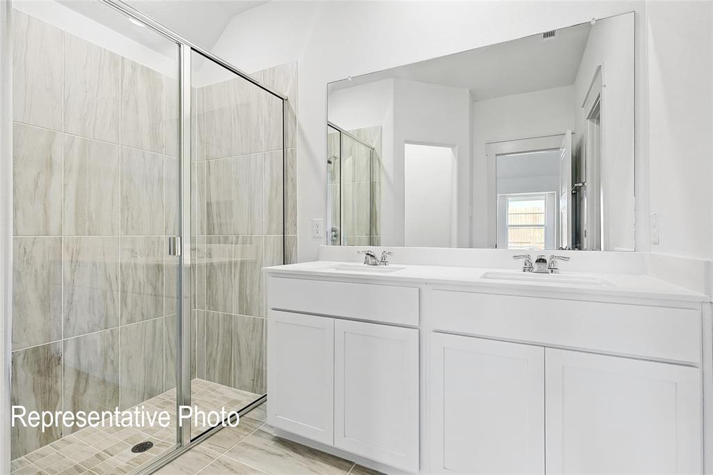 2709 Baker Farm Road Forney, TX 75126 - Photo 7 of 10 Spacious bathroom featuring a dual vanity with white cabinetry, a large vanity mirror, and a glass-enclosed shower with full-height tile surround