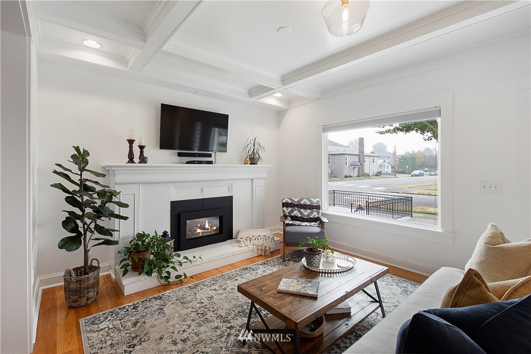 801 Ryan Avenue Sumner, WA 98390 - Photo 12 of 35 a living room with furniture a fireplace a flat screen tv and a large window