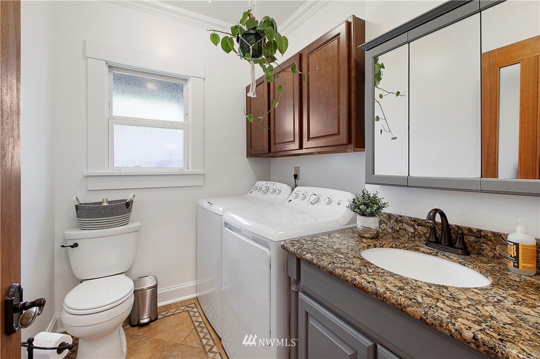 801 Ryan Avenue Sumner, WA 98390 - Photo 31 of 35 a bathroom with a granite countertop sink toilet and mirror