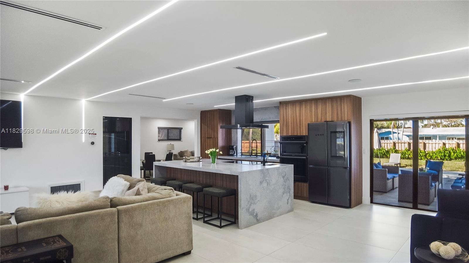 5131 Monroe Street Hollywood, FL 33021 - Photo 14 of 52 a living room with stainless steel appliances kitchen island granite countertop a refrigerator a stove and a sink with living room