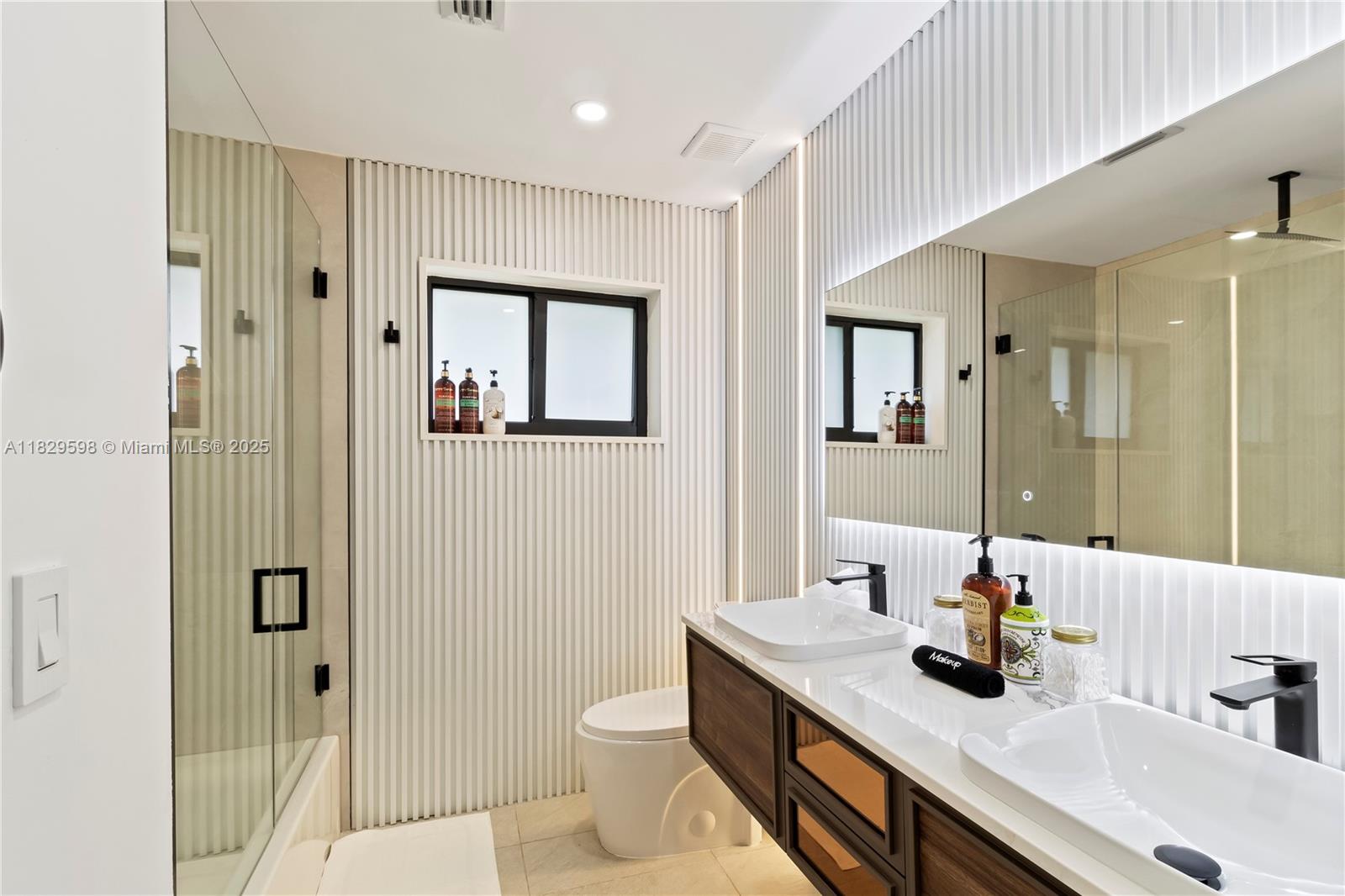 5131 Monroe Street Hollywood, FL 33021 - Photo 30 of 52 a bathroom with a sink a toilet a shower and a mirror