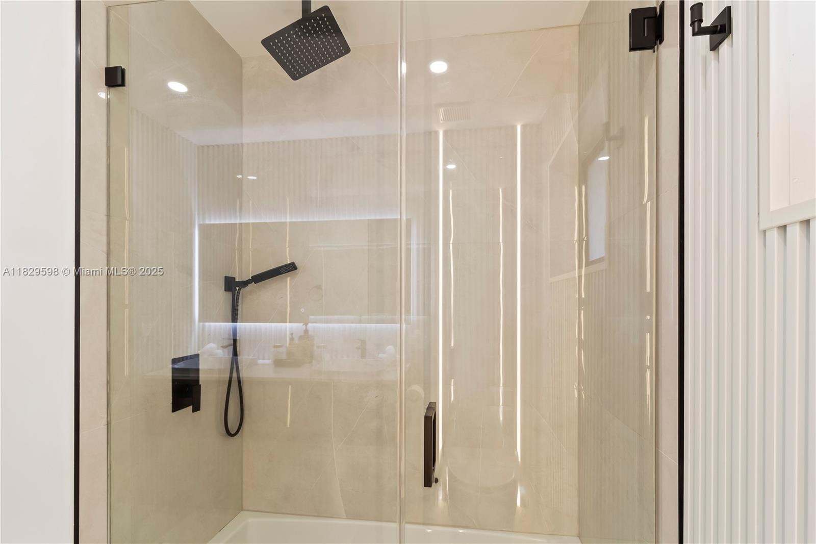 5131 Monroe Street Hollywood, FL 33021 - Photo 31 of 52 a bathroom with a glass shower door