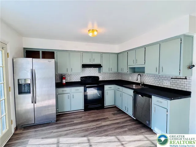 a kitchen with granite countertop a refrigerator and a sink