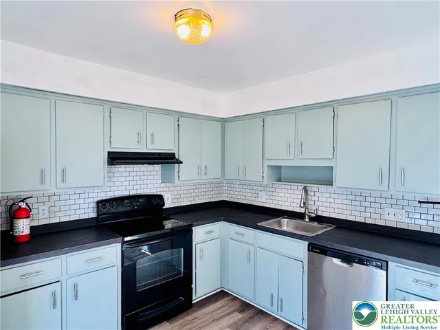 a kitchen with granite countertop a sink stainless steel appliances and cabinets
