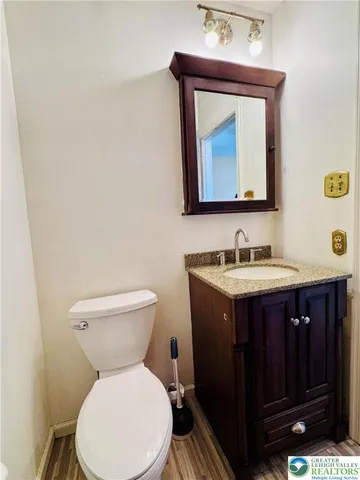 a bathroom with a toilet sink vanity and mirror